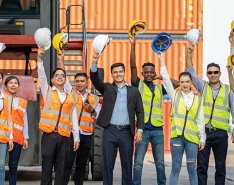 Workers holding hard hats/Adobe Stock